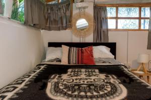Los Baños del IncaCabaña Kinti Q'umir Umiña en Kinti Wasi的一间卧室配有一张带黑白毯子的床
