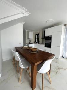 阿德耶Sunset of Duke#Luxury Costa Adeje的厨房配有木桌和白色椅子