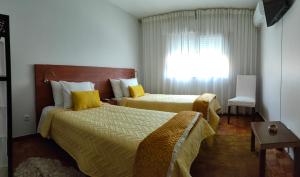 查韦斯Casa Valadim的酒店客房设有两张床和窗户。