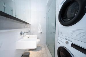 悉尼Eggie's Nest - Luxury City Apartment的一间带水槽和洗衣机的浴室