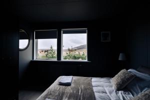 塞尔福斯Golden Circle Luxury Cottages的一间卧室设有一张床和两个窗户。