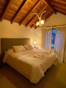 圣马丁德洛斯Samay Huasi - 3 dorm en suite - inmejorable ubicación - cochera cub的一间卧室配有一张大床和两条毛巾