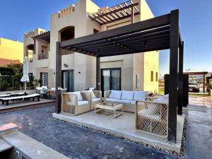 赫尔格达Luxurious Villa with Infinity Private Pool & Jacuzzi over Sabina Island's Lagoon的房屋前设有带沙发和桌子的庭院。