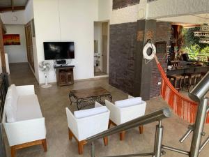 普拉多Casa Paraiso del Lago的客厅配有白色椅子和电视