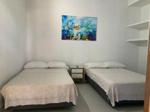 普拉多Casa Paraiso del Lago的墙上画画的房间里设有两张床