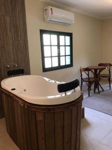 瓦伦萨Pousada Quinta dos Doges的客厅设有大浴缸,配有桌子