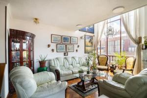 波哥大Habitaciones en un alojamiento -Anfitrion - Elias Di Caprio的客厅配有白色家具和大窗户