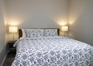 艾尔德里The Jade Place的一间卧室配有一张带两盏灯的蓝色和白色的床。