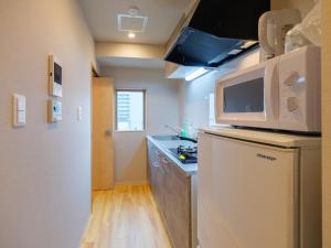 大阪DC桜の苑401洋式双人床的小厨房配有冰箱和微波炉。