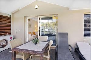 萨拉曼德湾Oaks Pacific Blue Pool spa more in complex的厨房以及带桌椅的起居室。