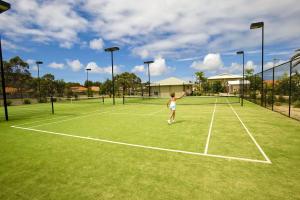 萨拉曼德湾Oaks Pacific Blue Pool spa more in complex的一名年轻女孩在网球场打网球