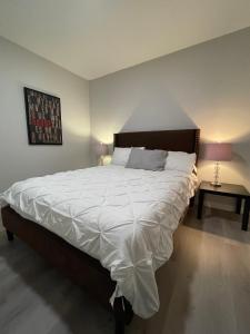 卡尔加里Private Cozy Secondary Suite, 2 Bedrooms, Separate Entrance的一间卧室配有一张带白色床单的大床