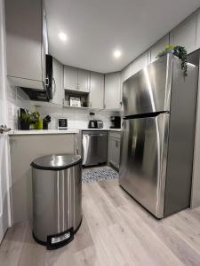 卡尔加里Private Cozy Secondary Suite, 2 Bedrooms, Separate Entrance的厨房配有不锈钢冰箱和垃圾桶