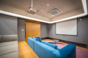 上海TULU途楼公寓(上海斜土路店)的客厅配有蓝色沙发和投影仪