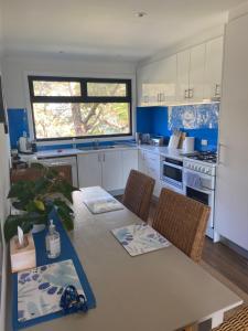 Clareville皮特沃特瑞弗吉科夫公寓的一间带桌椅的厨房和一间带蓝色调的厨房
