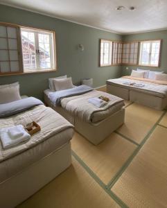 妙高Myoko Forest Lodge的带3张床的窗户客房