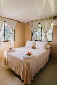波拉波拉Vue imprenable sur le lagon de Bora Bora的一间卧室配有一张白色大床,床上有鲜花