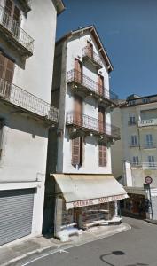 卢尔德Chez Marie et Didier Chalet saint Jacques的带阳台的白色建筑和商店