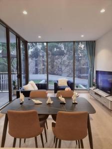 悉尼Sapphire Royale Suite in Macquarie Park的客厅配有桌椅和沙发