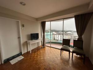 金马仑高原Little Star Hotel & Apartments的客厅配有电视和桌椅