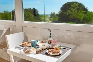 丽都阿德里亚诺Hotel Residence Le Dune breakfast included的餐桌,餐桌上放着盘子和窗户