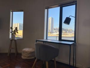 墨尔本Superb City Views - Apartment, work or just relax!的窗户客房内的桌椅