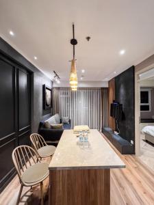 万隆R30 Apartemen Gateway Pasteur 2BR Daymentroom的厨房以及带桌椅的起居室。