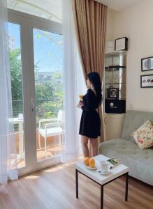 胡志明市CHEZ LOTUS VN的站在客厅的女人,看着窗外