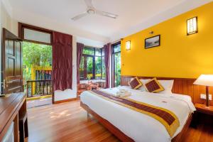 会安Hoi An Green Riverside Oasis Villa的一间卧室设有一张黄色墙壁的大床