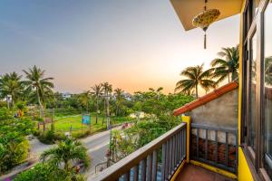 会安Hoi An Green Riverside Oasis Villa的阳台享有街道和棕榈树的景致。