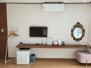木浦市Cheukhu-dong 19street Guesthouse的客房设有一张带电视和镜子的书桌。
