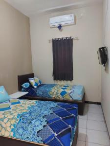 JomblangPenginapan Sriwijaya Semarang的小型客房 - 带2张床和窗户