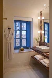 伊兹拉Orloff Legacy Suites Hydra的带浴缸、水槽和窗户的浴室