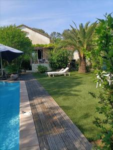 土伦Villa féeric的后院设有游泳池、桌子和长凳