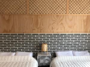 木浦市Cheukhu-dong 19street Guesthouse的一间卧室设有两张床和砖墙