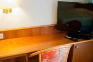 施泰恩巴赫陶努斯斯坦巴克斯塔德特酒店的一张木桌、一台电视和一把椅子
