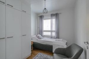 约恩苏Kotimaailma Joensuu - Saunallinen kolmio keskustassa的一间小卧室,配有一张床和一把椅子