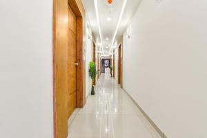 艾哈迈达巴德FabHotel Elite Inn I的医院的走廊,铺着白色瓷砖地板,设有走廊