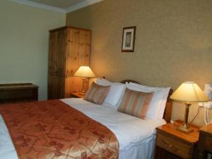 格伦贝赫Towers Hotel Glenbeigh的一间卧室配有一张大床和两盏灯