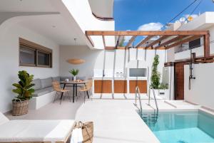 拉多斯Mariann Premium Suites的一座带游泳池和用餐室的房子
