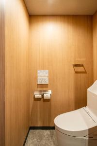 东京Section L Kuramae - Asakusa的浴室配有白色卫生间和木墙