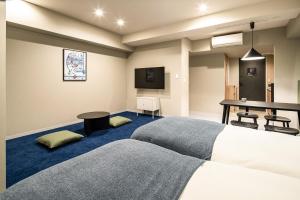 东京Section L Kuramae - Asakusa的酒店客房设有两张床和一张桌子。