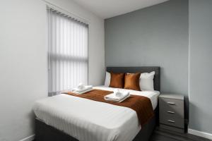 利物浦Vichy - Strathcona Suites, Houses in Wavertree的一间卧室配有一张大床和两条毛巾