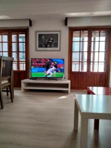 帕德隆EL RINCON DE LUZ的客厅配有餐桌上的平面电视