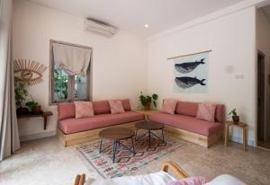 塞米亚克Kresna By The Sea By Kresna Hospitality的客厅配有粉红色的沙发和桌子