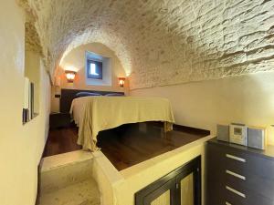 奥斯图尼Casa Vega的石墙客房的卧室配有一张床