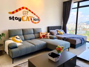 乔治市Beacon Executive Suite by stayCATion Homestay的客厅配有沙发和1张床