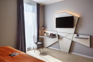 杜塞尔多夫the niu Hub的酒店客房配有一张床和一张书桌及一台电视