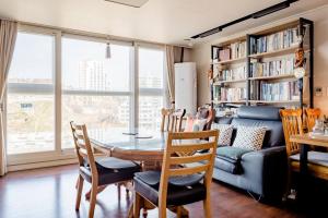 首尔天空温馨之家民宿的一间带桌椅和沙发的用餐室