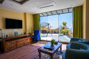 PanepaAagantuk Resort的客厅配有平面电视和蓝色椅子。